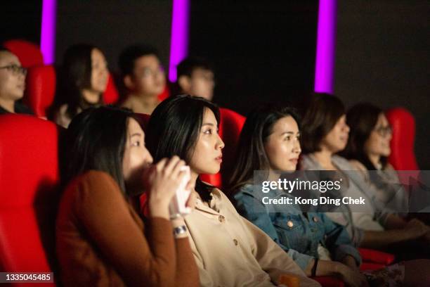 group of people enjoying watching movie at movie theater. - asian cinema stock pictures, royalty-free photos & images