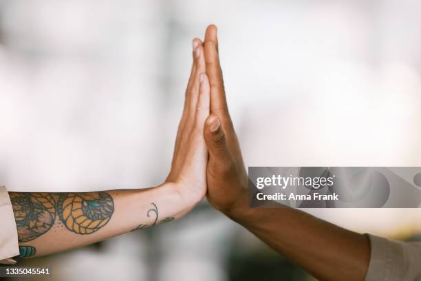 closeup of two colleagues high-fiving - hi five stockfoto's en -beelden