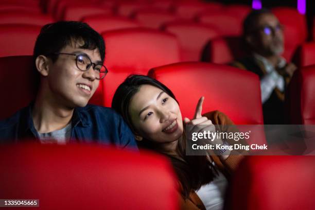 close up asian chinese couple at the movies eating popcorn and watching a film in cinema movie theater - asian cinema bildbanksfoton och bilder