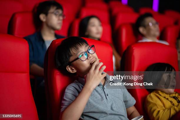 asiatischer chinesischer teenager junge seine familie genießt film im kino kino - good boy premiere stock-fotos und bilder