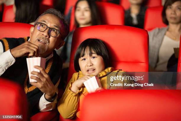 asian chinese grandfather and granddaughter together with group of audience watching movie in cinema enjoying the show excitement - asian watching movie stock pictures, royalty-free photos & images