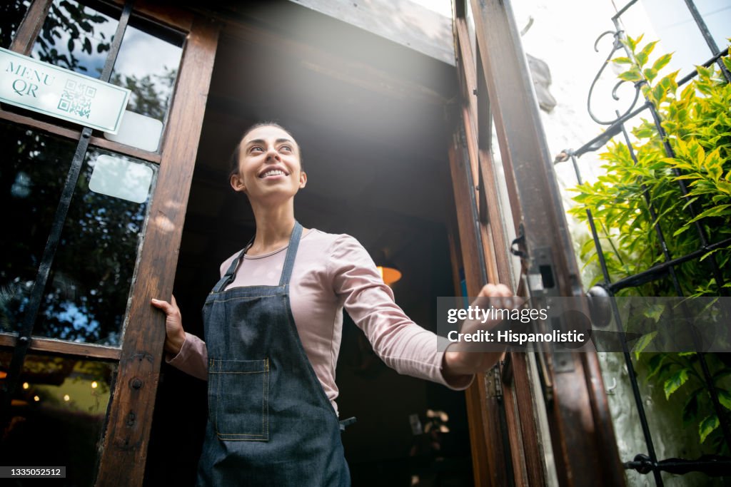 Serveuse travaillant dans un restaurant et ouvrant la porte