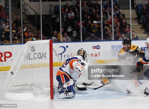 Patrice Bergeron of the Boston Bruins scores past Rick DiPietro of the New York Islanders at 7:08 of the first period at the Nassau Veterans Memorial...