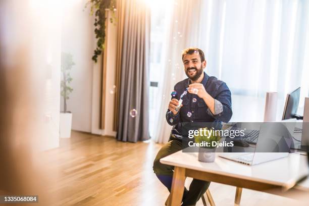 happy young man blowing bubbles at home. - bubbles happy stockfoto's en -beelden