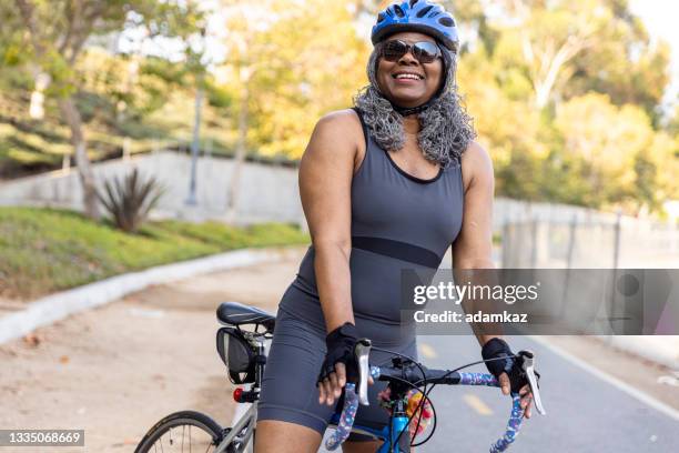 senior black woman riding bicycle - women cycling stock pictures, royalty-free photos & images