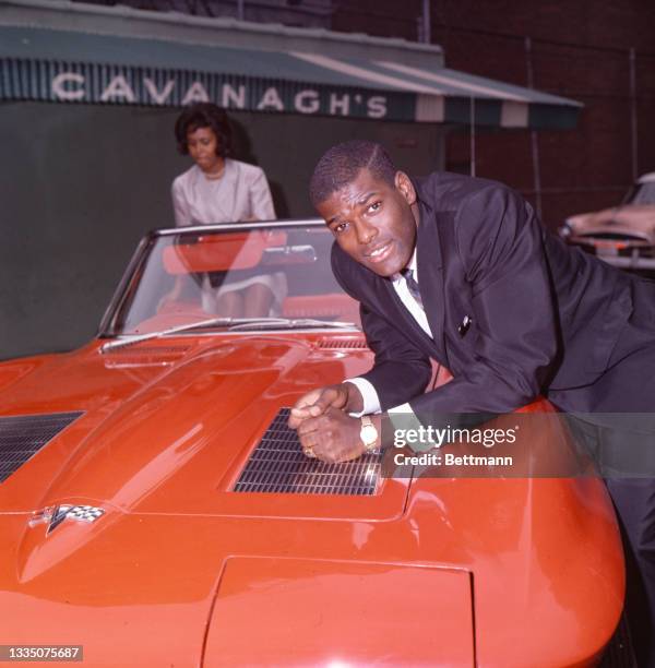 St. Louis Cardinals pitching ace Bob Gibson and his wife, Charlene, happily take possession of a 1965 sports car . Sport Magazine awarded the car to...