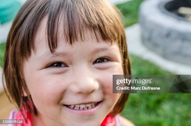 headshot of mixed race girl on backyard patio - métis stock pictures, royalty-free photos & images