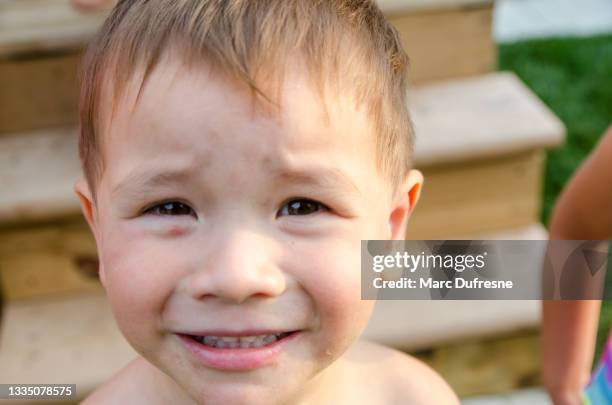 headshot of mixed race boy on backyard patio - métis stock pictures, royalty-free photos & images