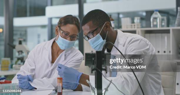 shot of two scientists analysing samples in a lab - medical research mask stock pictures, royalty-free photos & images