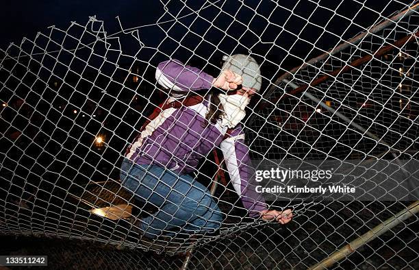 Demonstrator jumps on a chain link fence she helped to pull down November 19, 2011 in Oakland, California. Occupy Oakland protesters, calling for a...