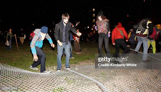 Demonstrators stomp on a chain link fence they pulled down November 19, 2011 in Oakland, California. Occupy Oakland protesters, calling for a "mass...