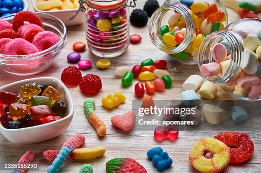 Vue à angle élevé gros plan d’un assortiment de gelées colorées, de sucettes, de bonbons et de guimauves. Vue à angle élevé gros plan d’un assortiment de gelées colorées, de sucettes, de bonbons et de guimauves.