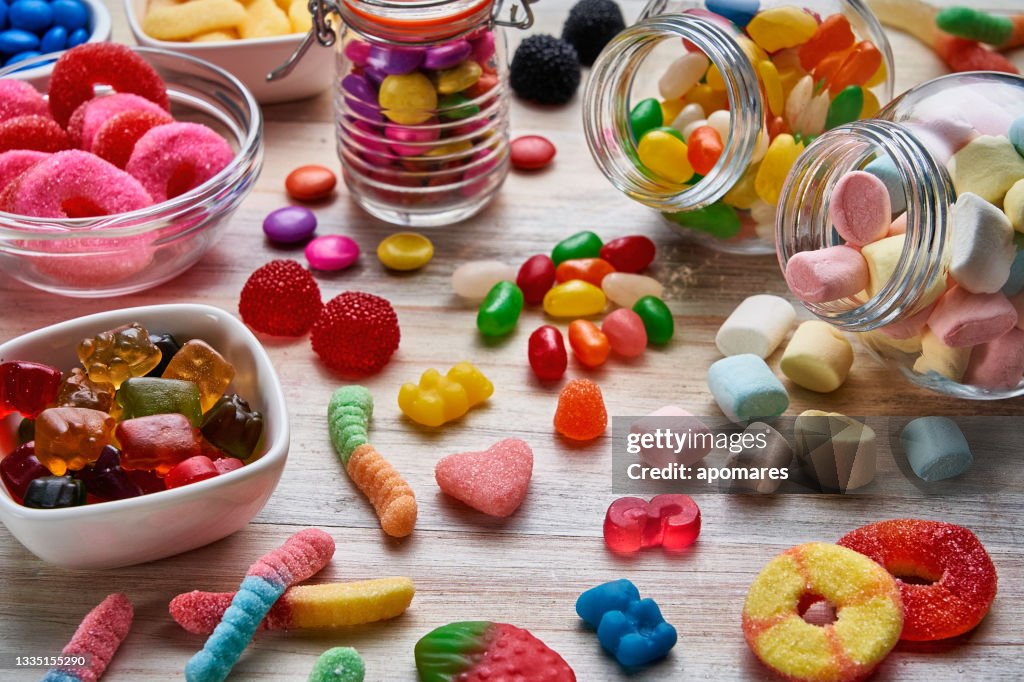 High angle view close-up of an assortment of colorful jellybeans, lollipops, candies and marshmallows.