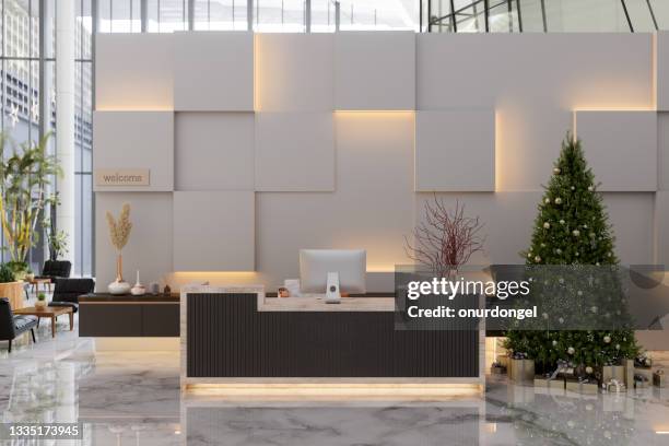 luxury hotel or company lobby entrance with reception desk, christmas tree, ornaments, gift boxes and black colored leather armchairs - lobby screen stock pictures, royalty-free photos & images