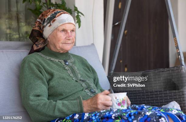 portrait of a grandmother on the porch of the house. - pension ukraine stock pictures, royalty-free photos & images