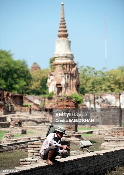Thailand-weather-floods-heritage,FOCUS by Kelly Macnamara In a picture taken on November 17 a worker takes rests after pumping out floodwaters from...