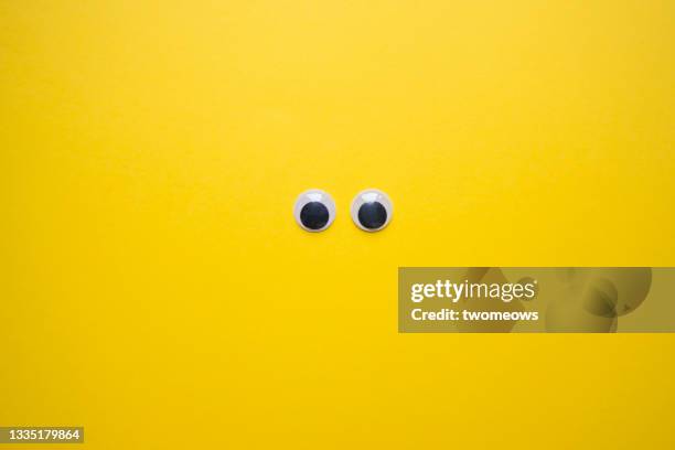 doll eyes on yellow background. - bulbo oculare foto e immagini stock