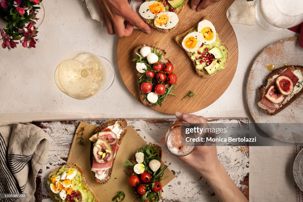 Mix of different types of toast and bruschetta on wooden board