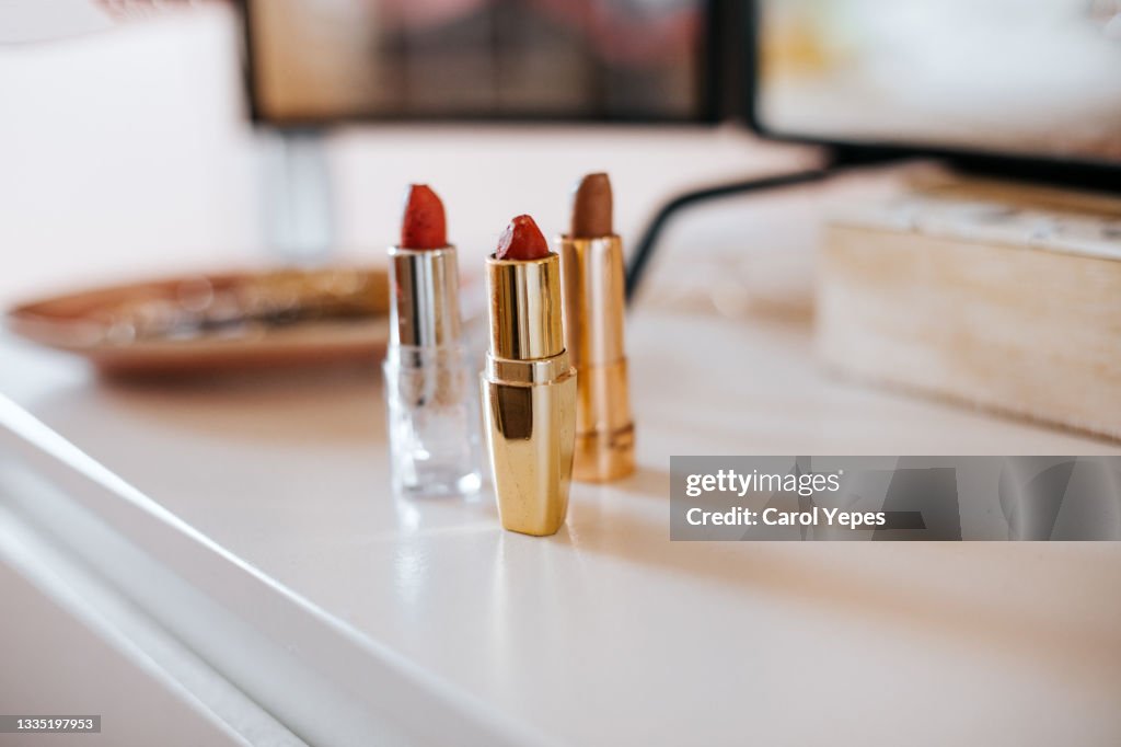 Three red lipsticks on dressing table.Indoor