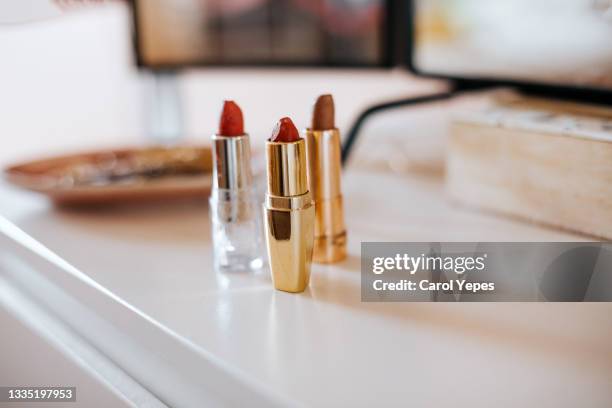 three red lipsticks  on  dressing table.indoor - vanity lights stock pictures, royalty-free photos & images