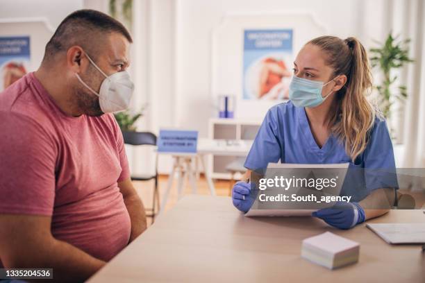 man came to to receive a vaccine - overweight stock pictures, royalty-free photos & images