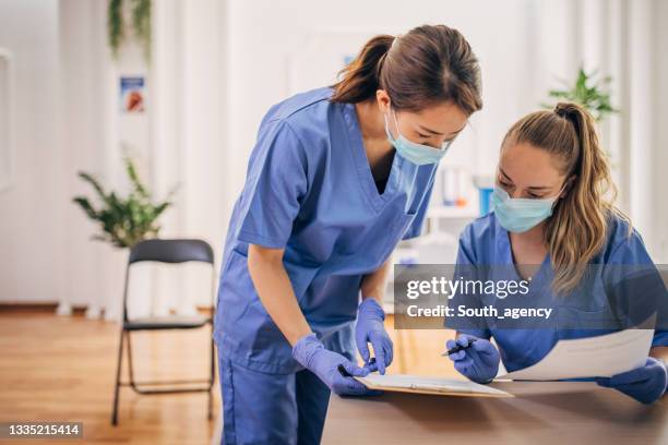 medical workers at vaccination center - prevention stock pictures, royalty-free photos & images