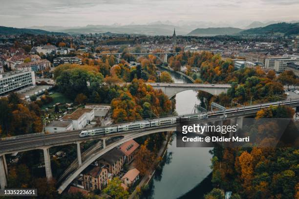 commuter train on a bridge over the aar river that flow around bern old town in switzerland - jura suisse photos et images de collection