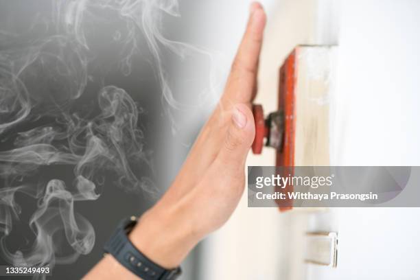 the hand of man is pulling fire alarm on the wall next to the door - breaker box stockfoto's en -beelden