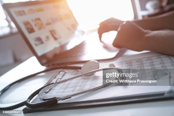 close-up of hands of a nurse typing on laptop - blankett för försäkringsanspråk bildbanksfoton och bilder