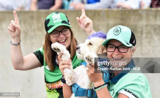 An Oval Invincibles fan watches on alongside their pet dog during the Eliminator match of The Hundred between Oval Invincibles Women and Birmingham...