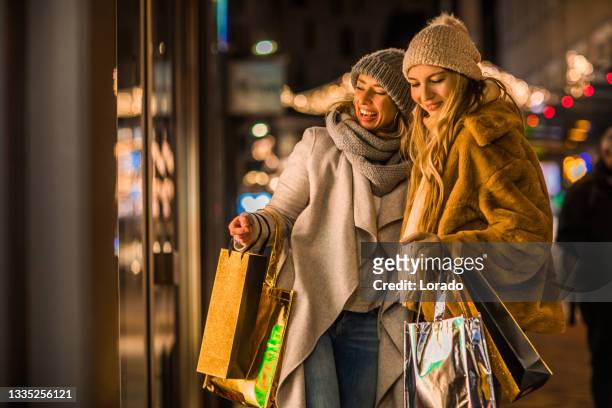 zwei schöne frauen beim wintereinkauf - amsterdam noel stock-fotos und bilder