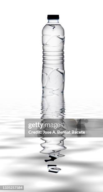 plastic water bottle on a white background, reflected on a water surface. - water bottle splash stock pictures, royalty-free photos & images