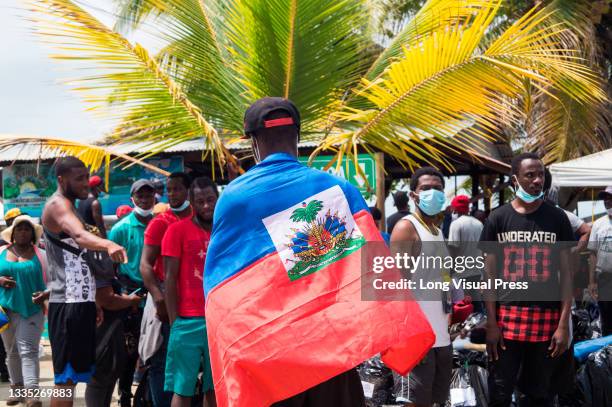 Haitian migrant with Haiti's national flag as thousands of Haitian, African and Cuban migrants that came from Chile, Brazil or Suriname, try to pass...