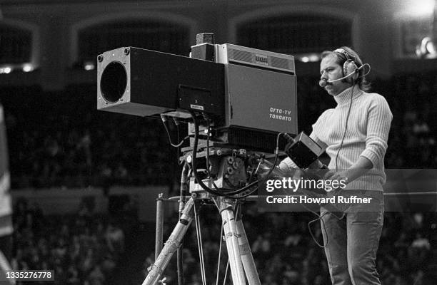 View of camera operator as he films a match on the first day of the 62nd Davis Cup final, Cleveland, Ohio, November 30, 1973. The match marked the...