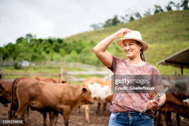 smiling female farm manager standing in a corral on a cattle ranch - work routine imagens e fotografias de stock