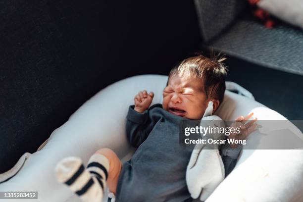 newborn baby girl crying on bed - huilen stockfoto's en -beelden