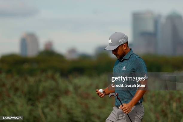 Xander Schauffele of the United States looks at his golf ball as he walks off the 14th green during the second round of THE NORTHERN TRUST, the first...