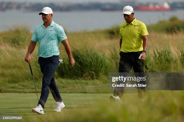 Brooks Koepka of the United States and Hideki Matsuyama of Japan walk to the 14th green during the second round of THE NORTHERN TRUST, the first...