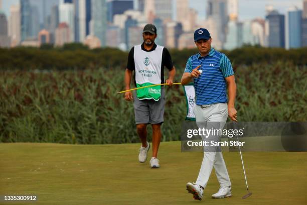 Jordan Spieth of the United States waves after putting on the 14th hole as caddie Michael Greller looks on during the second round of THE NORTHERN...