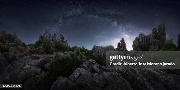 panoramic night landscape of karst limestone rock, against the milky way arch in a starry sky - paraje natural torcal de antequera stock-fotos und bilder