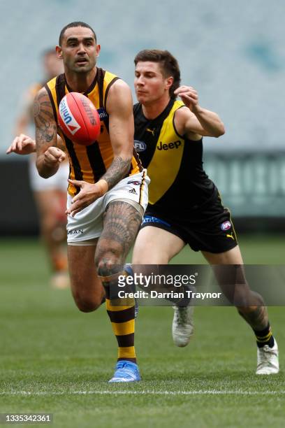 Shaun Burgoyne of the Hawks handballs during the round 23 AFL match between Richmond Tigers and Hawthorn Hawks at Melbourne Cricket Ground on August...