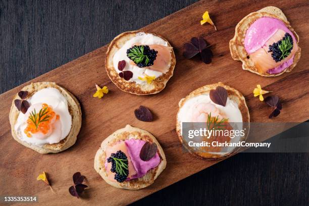 blinis with creme fraiche, salmon and caviar - savoury food stock pictures, royalty-free photos & images