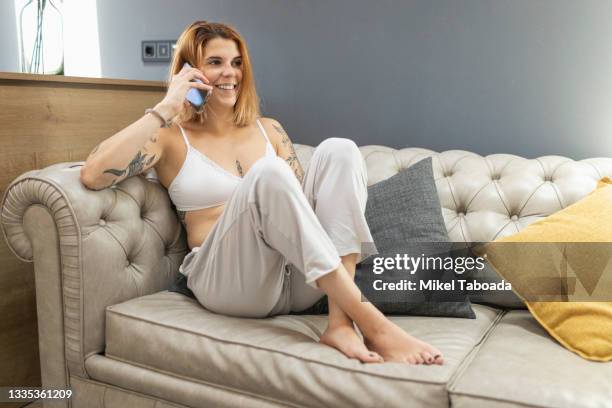 woman having smartphone conversation on couch - white pants bildbanksfoton och bilder