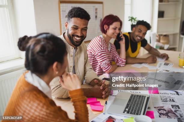 group of young magazine editors with laptop indoors in office, working. - newspaper reporter stock pictures, royalty-free photos & images