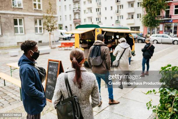 line of customers waiting for service at food truck - 人の列 ストックフォトと画像