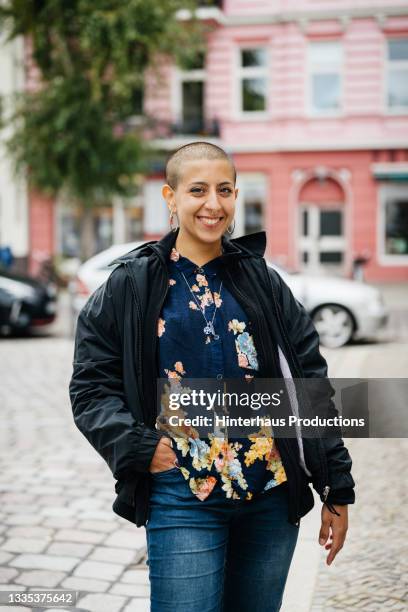 portrait of woman with shaved head smiling - shaved head stock pictures, royalty-free photos & images