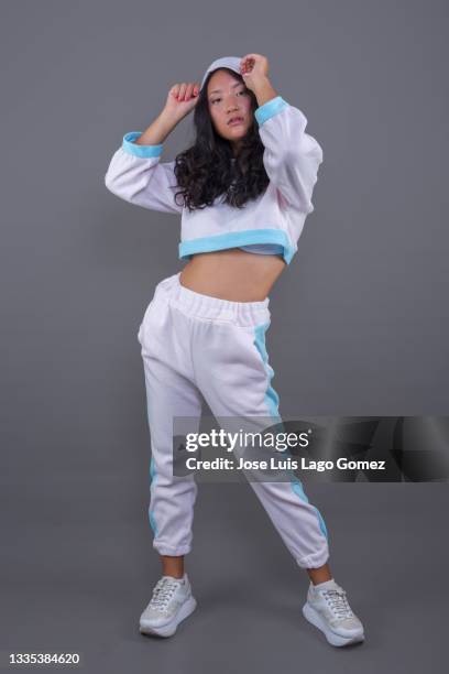 chinese girl in hip hop attire, standing with pose and attitude corresponding to her musical tendency. - asian cheerleaders stock-fotos und bilder