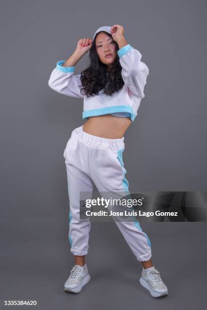 chinese girl in hip hop attire, standing with pose and attitude corresponding to her musical tendency. - alicante street stock pictures, royalty-free photos & images