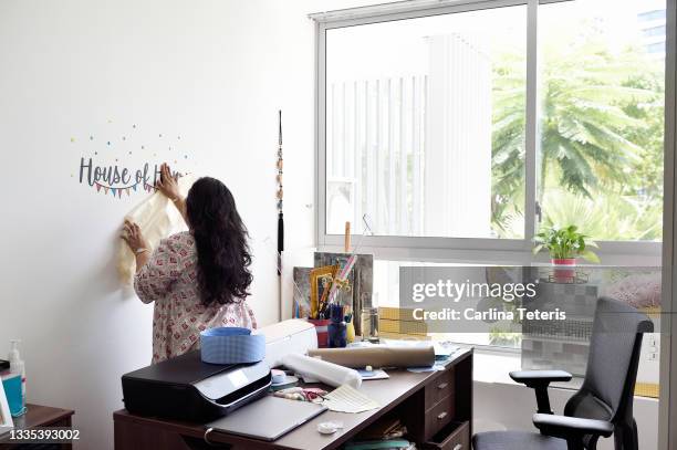 business woman puts up company sign - achievement logo stock pictures, royalty-free photos & images