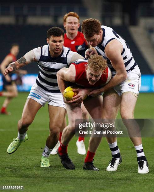 Clayton Oliver of the Demons is tackled by Gary Rohan of the Cats and Brandan Parfitt of the Cats during the round 23 AFL match between Geelong Cats...